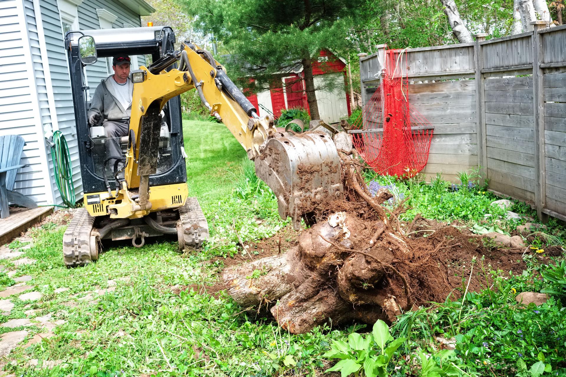 Heavy equipment construction machine digging a stump from the ground.