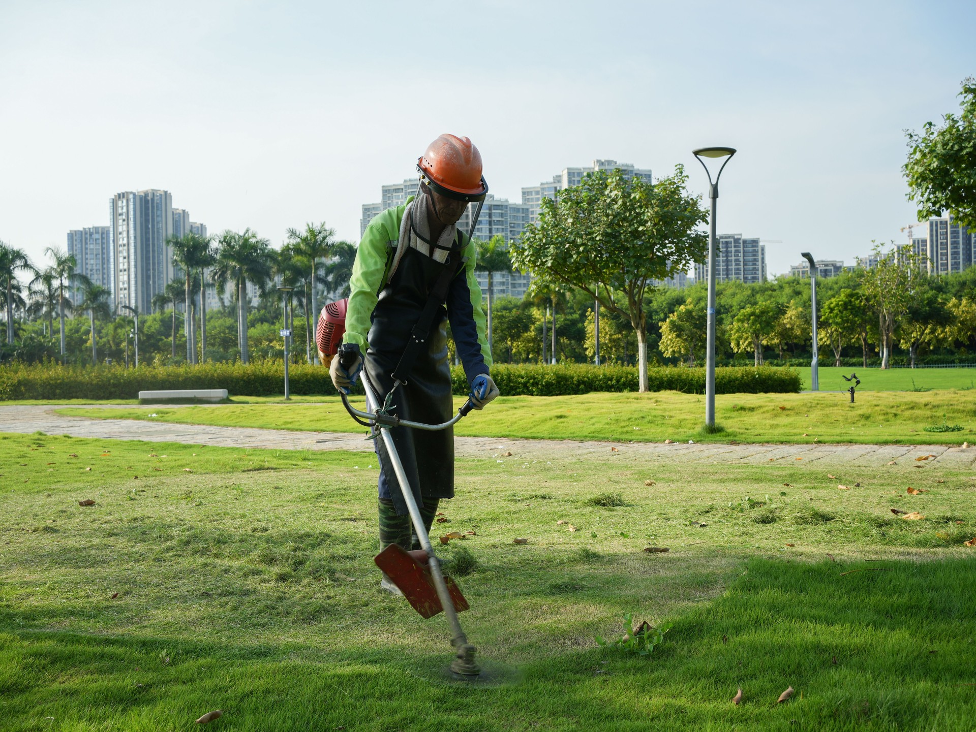 Workers mowing grass in the park